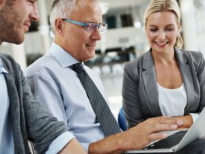 due uomini e una donna guardano un tablet in ufficio