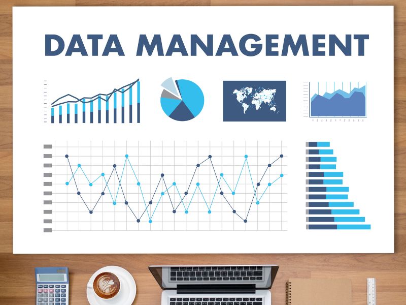 foglio su una scrivania con scritto data management e dei grafici